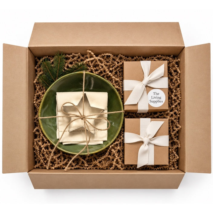 Breakfast Gift Set for Two in a kraft gift box with ivory napkins, olive-green bowls, ribbon-tied boxes and an evergreen sprig