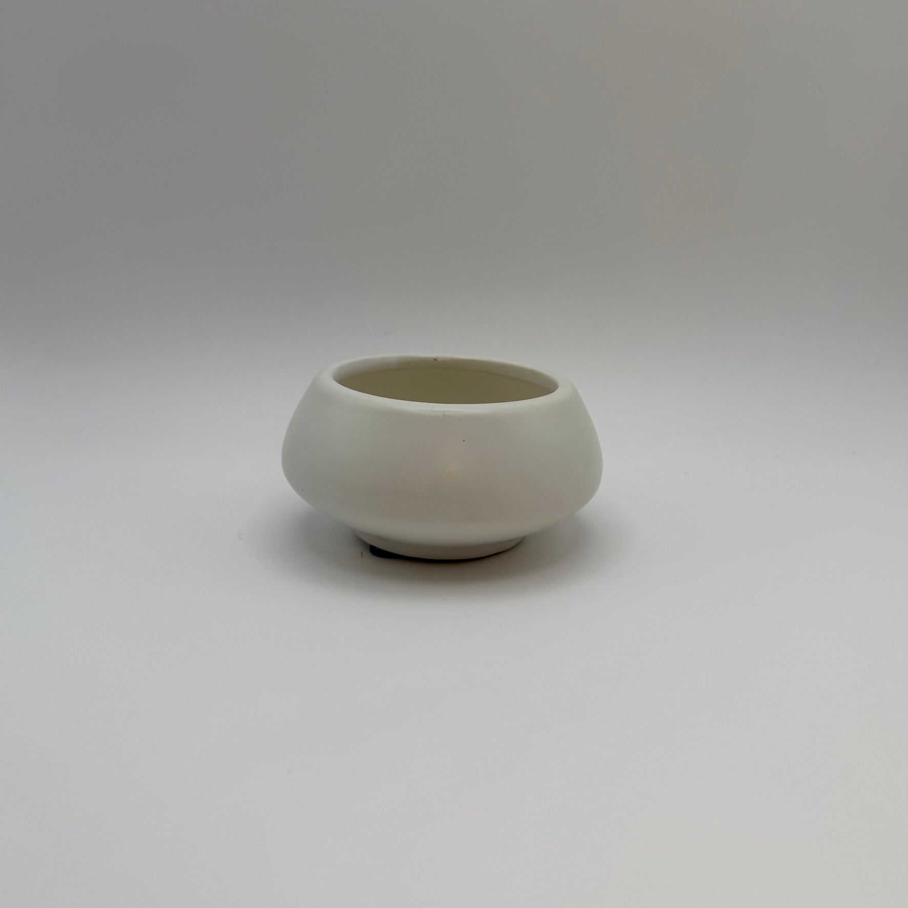 White ceramic decorative bowl with a raised base, front view