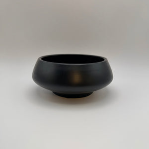 Black ceramic decorative bowl with a raised base, side view