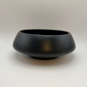Black low-profile ceramic bowl with a wide opening, front view