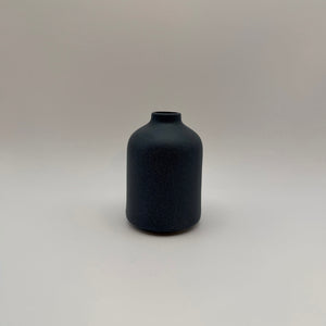 Dark gray sand-glazed ceramic bud vase viewed from the front