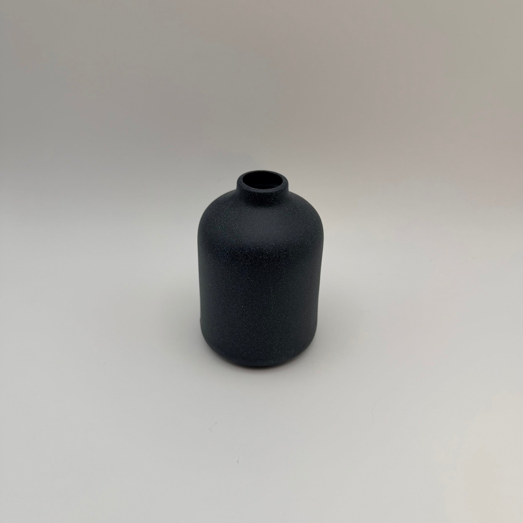 Dark gray sand-glazed ceramic bud vase viewed from above