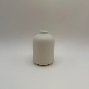 White sand-glazed ceramic bud vase viewed from the front