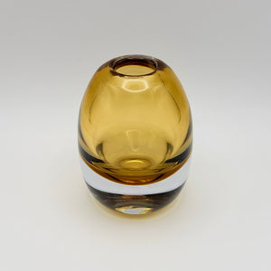 Small rounded amber glass bud vase on a light background