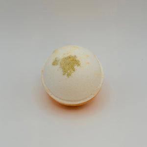 Round cream bath bomb topped with dried botanicals