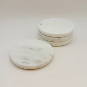 White marble coasters with gray veining, three stacked and one laid flat