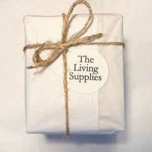 White gift parcel tied with twine and a The Living Supplies label
