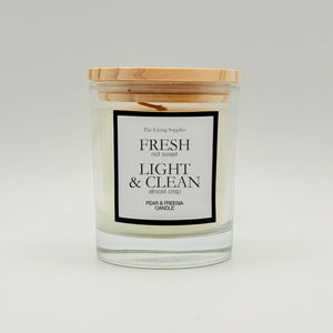 Pear and freesia candle in a clear glass jar with a wooden lid and black-bordered label