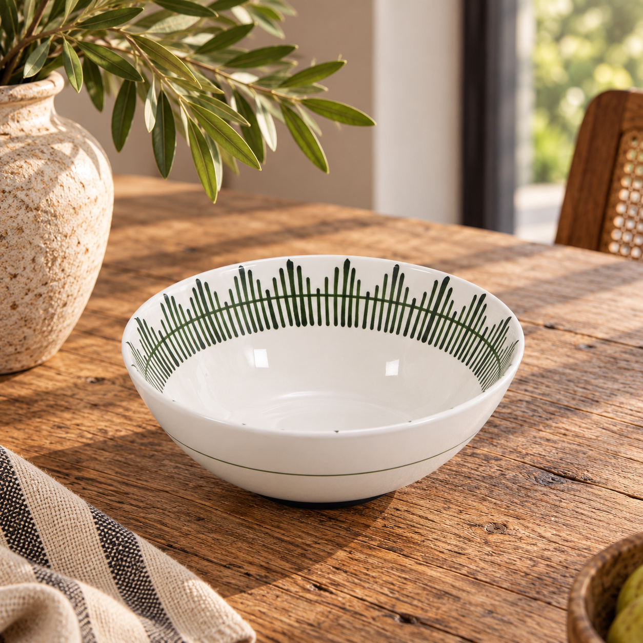 Giardino ceramic serving bowl with a green patterned rim on a wooden kitchen table