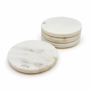 Four round white marble coasters with gray veining, three stacked and one laid flat, on a white background